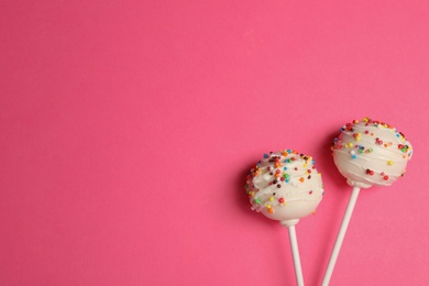 Bright delicious cake pops on color background, flat lay. Space for text