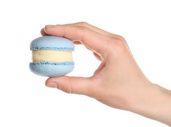 Photo of Woman holding delicious blue macaron on white background, closeup