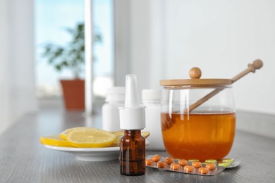 Nasal spray and different cold remedies on wooden table