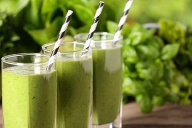 Photo of Fresh green smoothie and ingredients on table, closeup