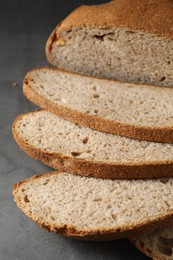 Photo of Freshly baked cut sourdough bread on grey table, top view