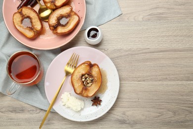 Delicious quinces baked with honey and walnuts on wooden table, flat lay. Space for text