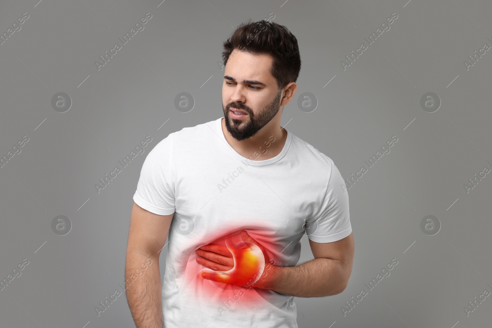 Image of Man suffering from abdominal pain on grey background. Illustration of unhealthy stomach