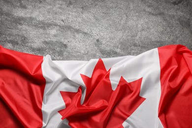 Photo of Flag of Canada on gray background, top view. Space for text