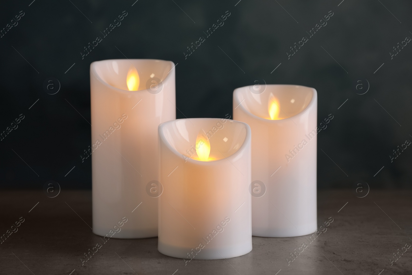 Photo of Beautiful decorative LED candles on grey table