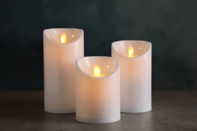 Photo of Beautiful decorative LED candles on grey table