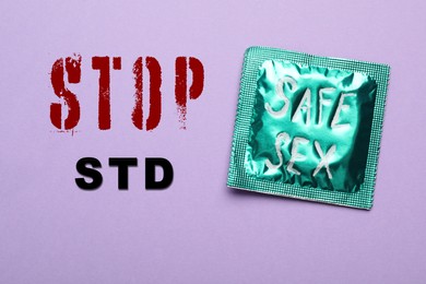 Image of Text STOP STD and green condom with phrase SAFE SEX on violet background, top view