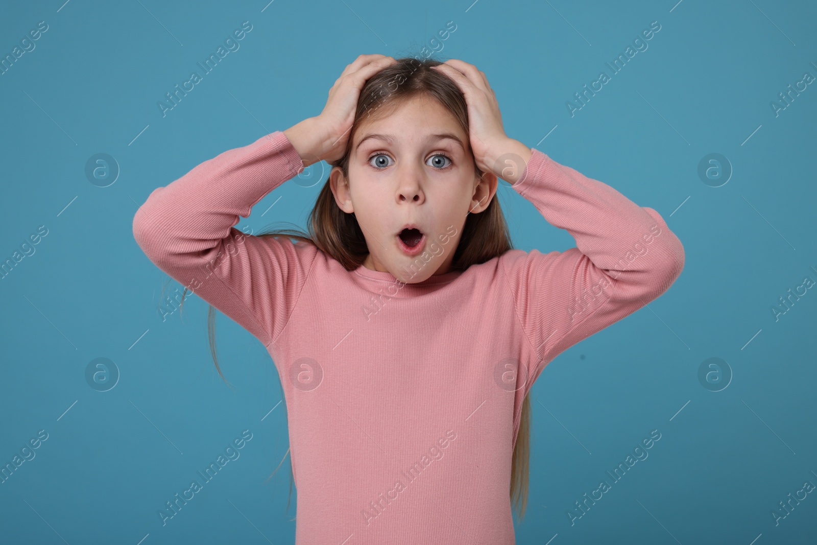 Photo of Portrait of surprised girl on light blue background