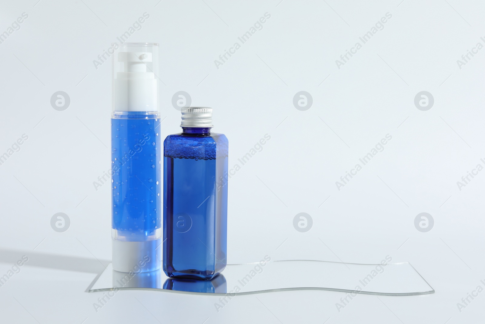 Photo of Different containers with cosmetic products on light background, space for text