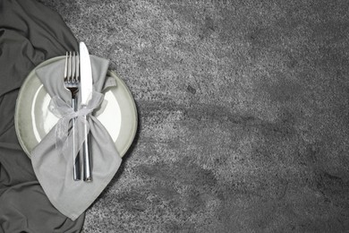 Stylish setting with elegant cutlery on grey table, top view. Space for text