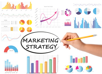 Image of Woman writing words Marketing strategy and charts on white background, closeup