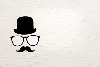 Photo of Flat lay composition with paper hat, glasses and moustache on light background