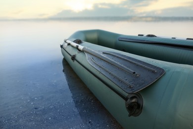 Inflatable rubber fishing boat at riverside, closeup. Space for text