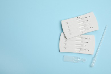 Photo of Disposable express hepatitis test kit on light blue background, flat lay. Space for text