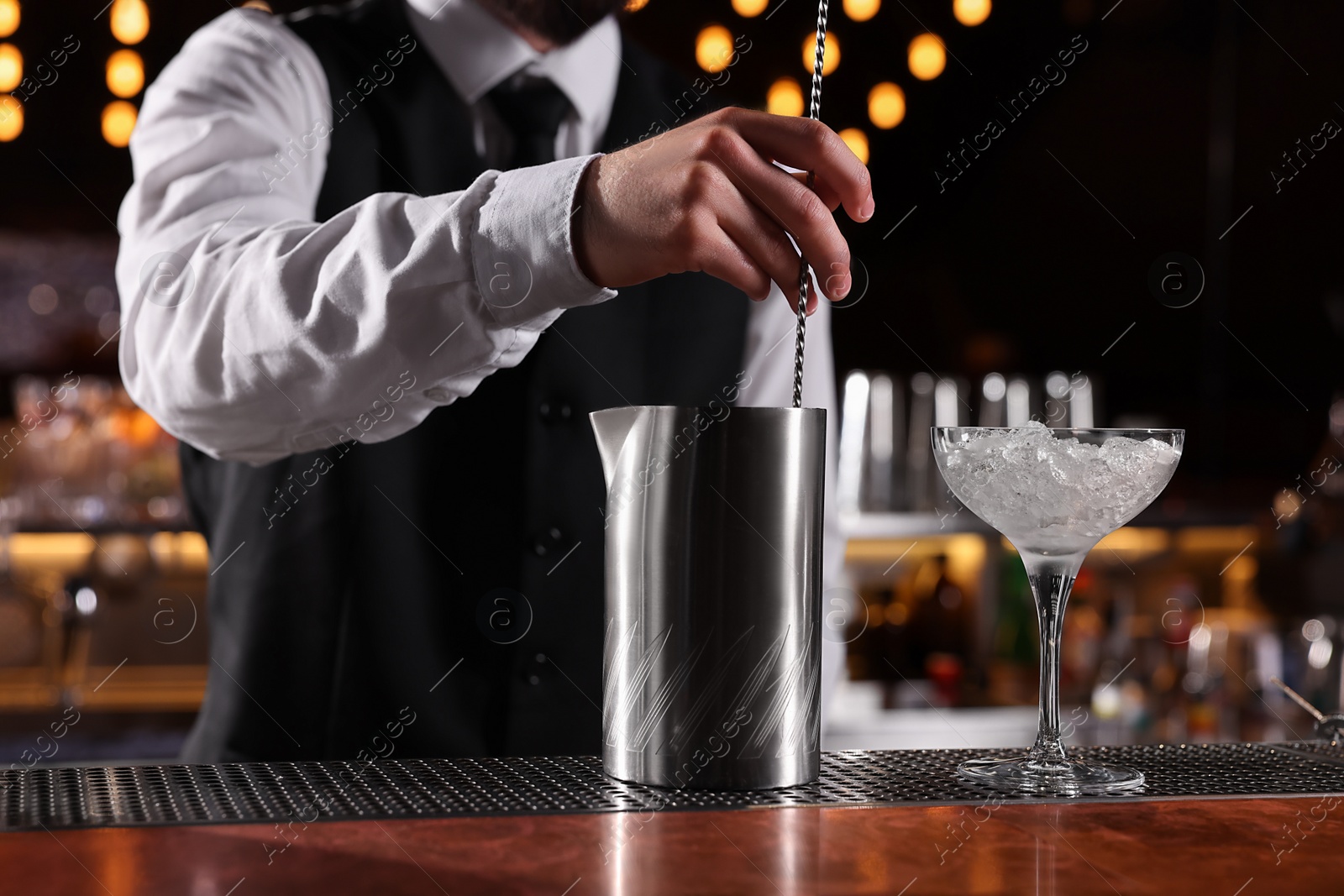 Photo of Bartender preparing fresh alcoholic cocktail at bar counter, closeup