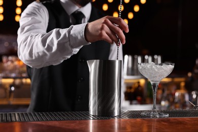 Photo of Bartender preparing fresh alcoholic cocktail at bar counter, closeup