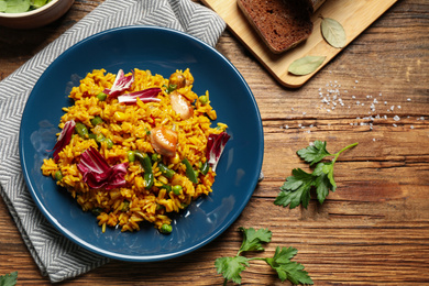 Delicious rice pilaf with chicken served on wooden table, flat lay