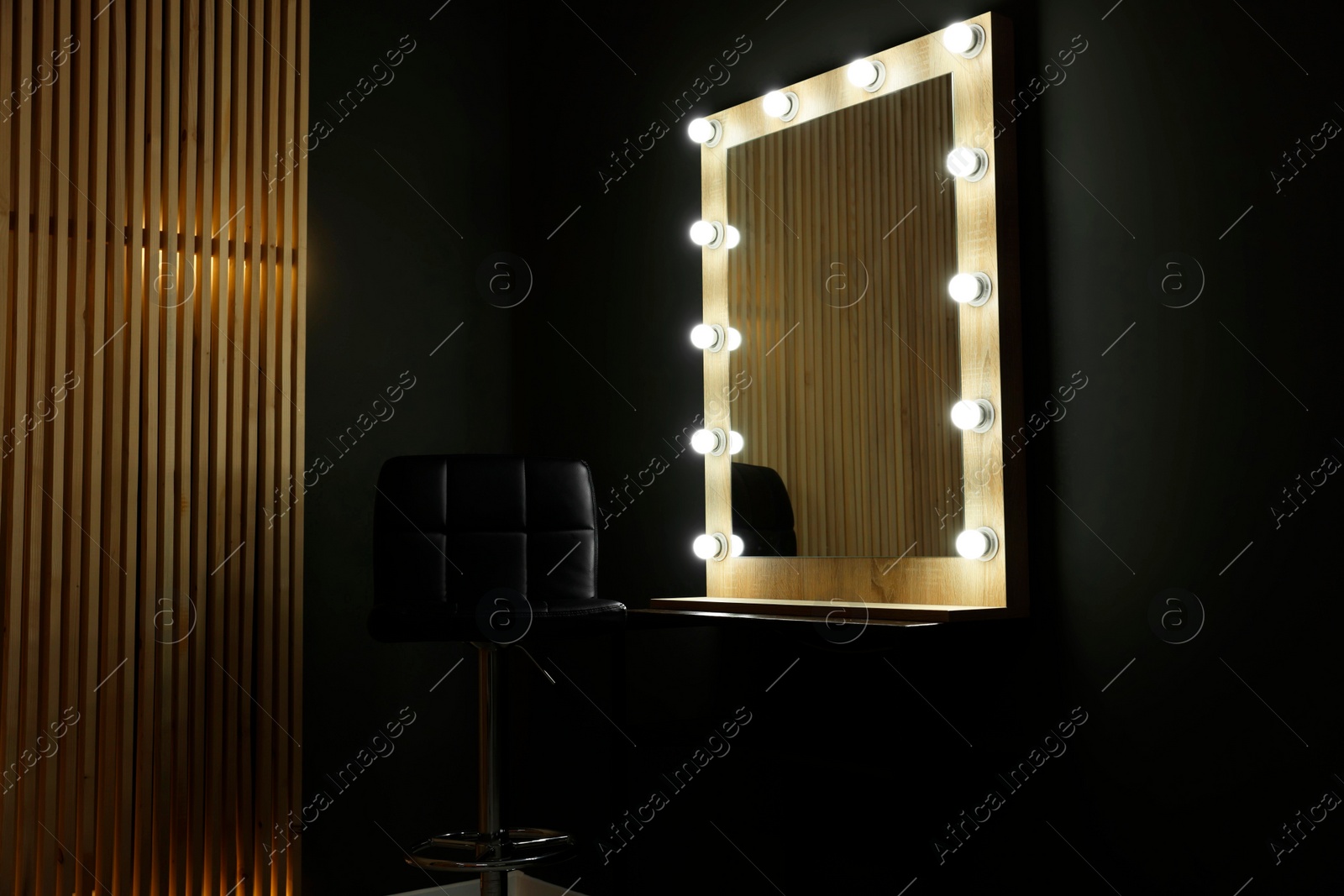 Photo of Beautiful mirror with light bulbs and chair in makeup room