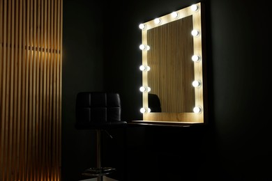 Photo of Beautiful mirror with light bulbs and chair in makeup room