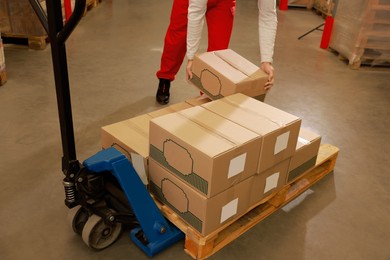 Image of Worker sorting cardboard boxes in warehouse, closeup. Logistics concept