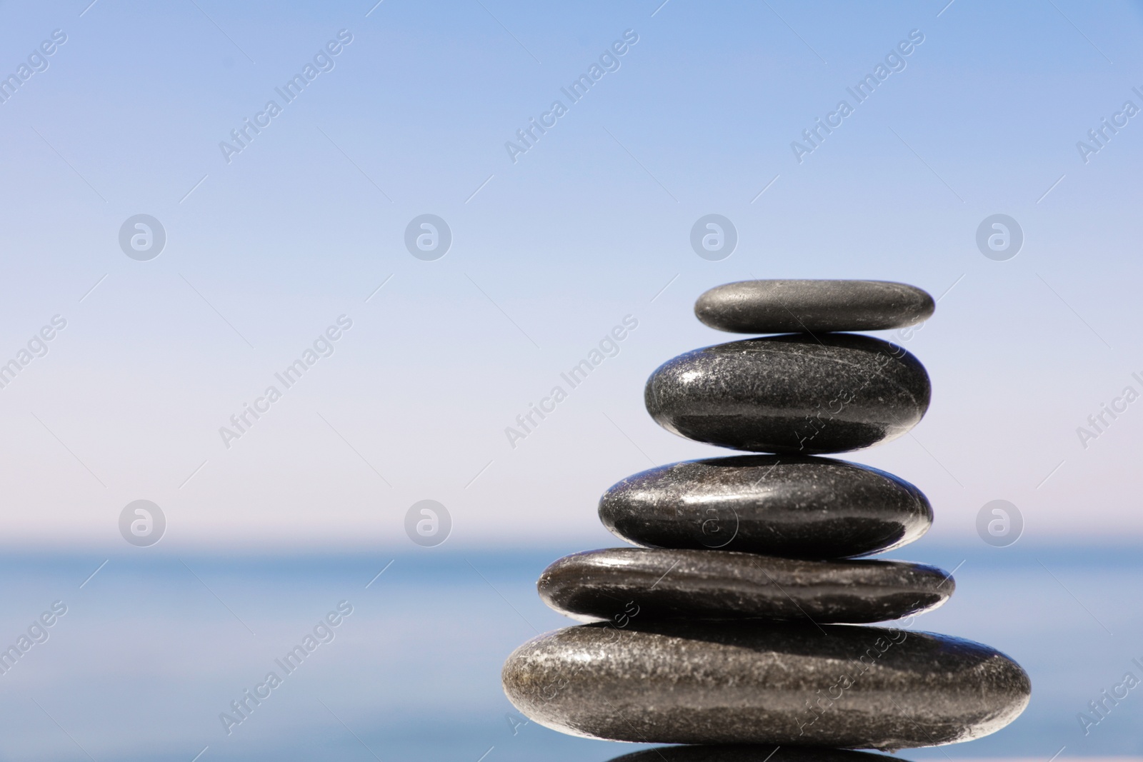 Photo of Stack of stones near sea, closeup. Space for text