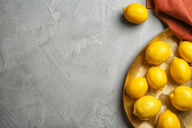Photo of Flat lay composition with plate of lemons on gray background
