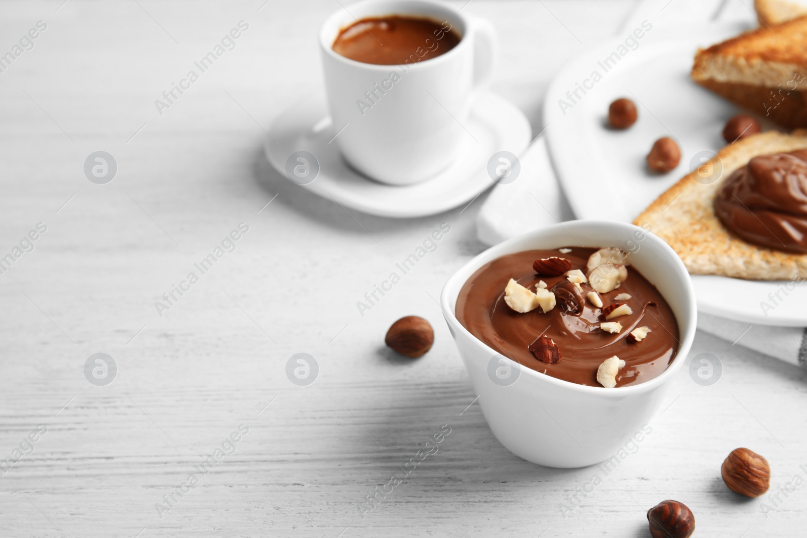 Photo of Chocolate cream with hazelnuts in dessert bowl served on table. Space for text