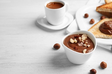 Chocolate cream with hazelnuts in dessert bowl served on table. Space for text