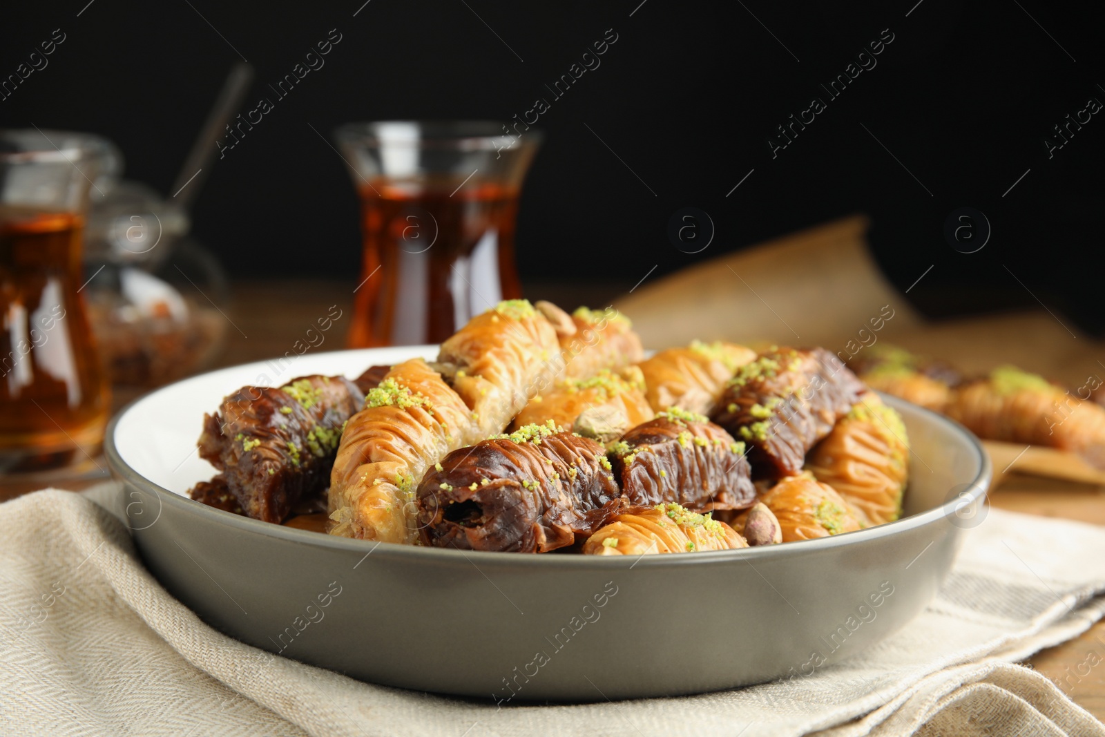 Photo of Delicious sweet baklava in bowl on table, closeup