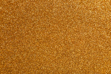 Photo of Beautiful shiny golden glitter as background, top view