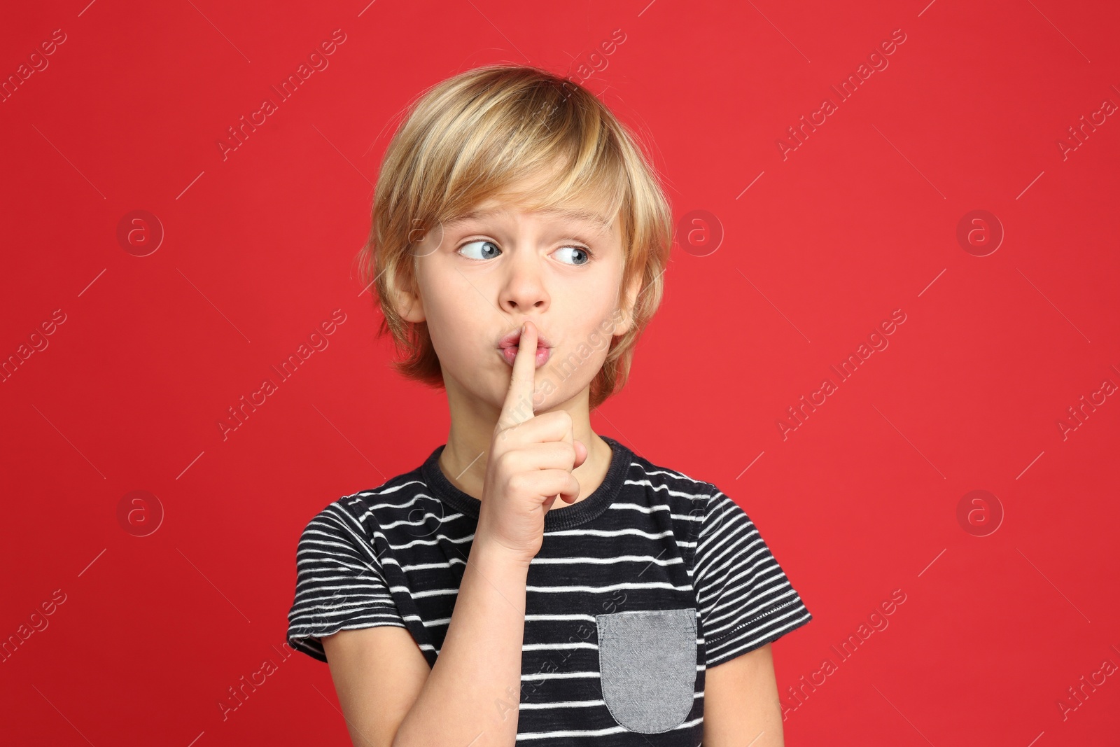 Photo of Portrait of cute little boy on red background