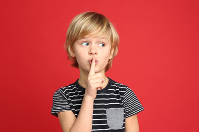 Photo of Portrait of cute little boy on red background