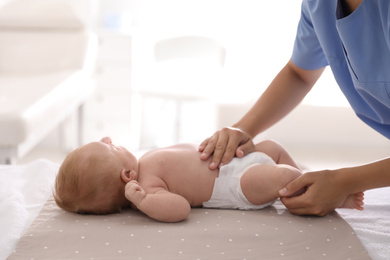 Doctor examining cute baby in clinic, closeup. Health care