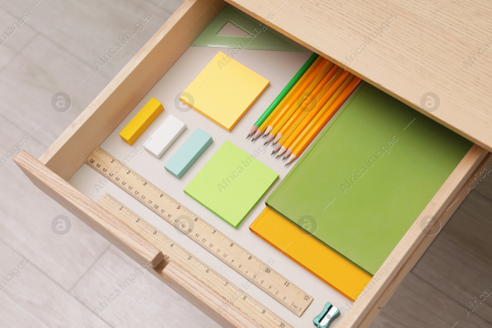 Photo of Office supplies in open desk drawer, above view