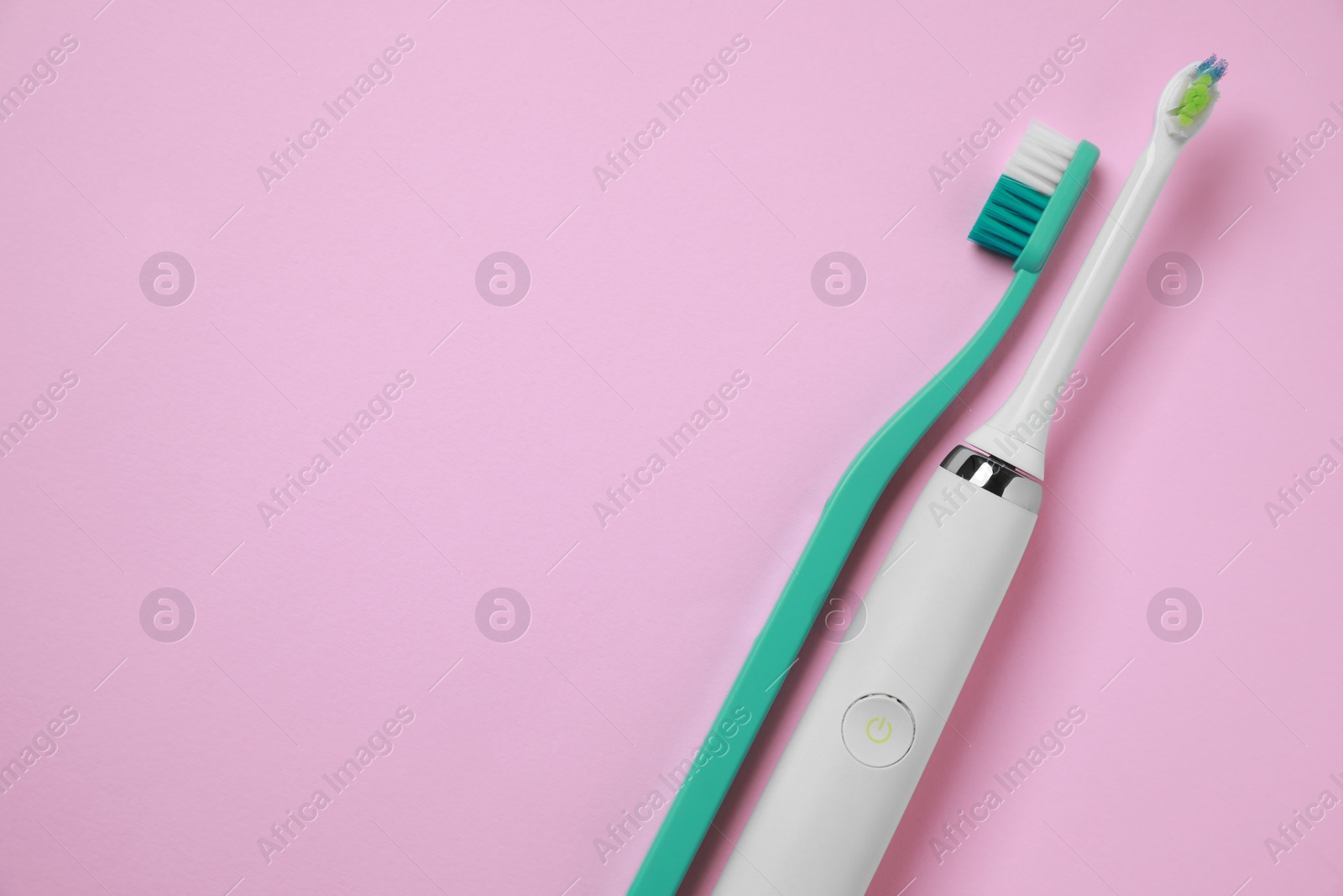 Photo of Electric and plastic toothbrushes on pink background, flat lay. Space for text