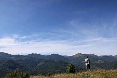 Photo of Man enjoying picturesque view of mountain landscape on sunny day