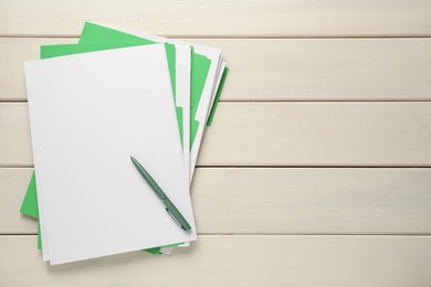 Light green files with blank sheets of paper and pen on white wooden table, top view. Space for text