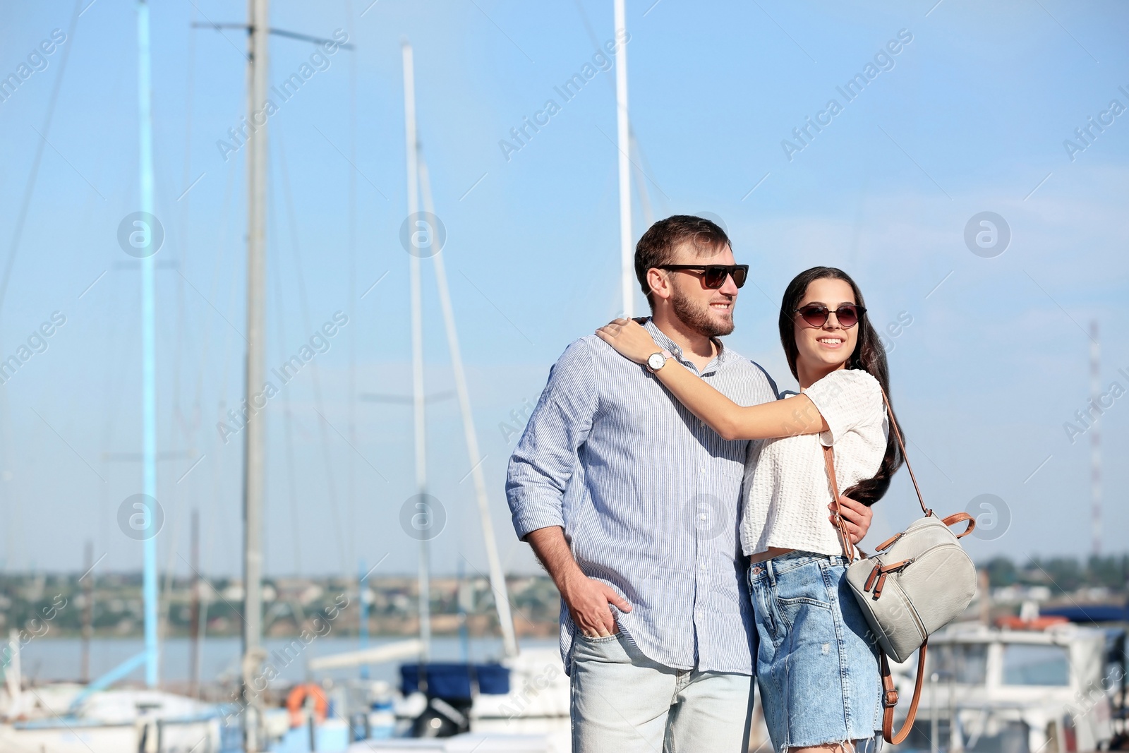 Photo of Young hipster couple in jean clothes on pier