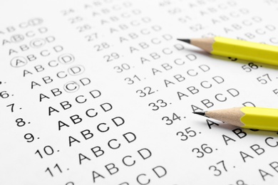 Photo of Yellow pencils on answer sheets, closeup view