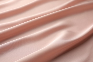 Crumpled pink silk fabric as background, closeup