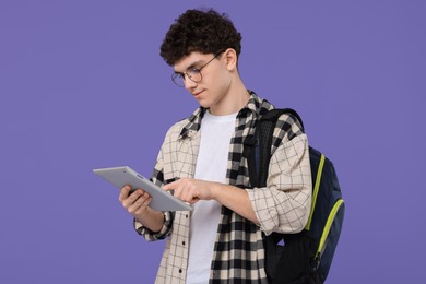 Photo of Portrait of student with backpack and tablet on purple background