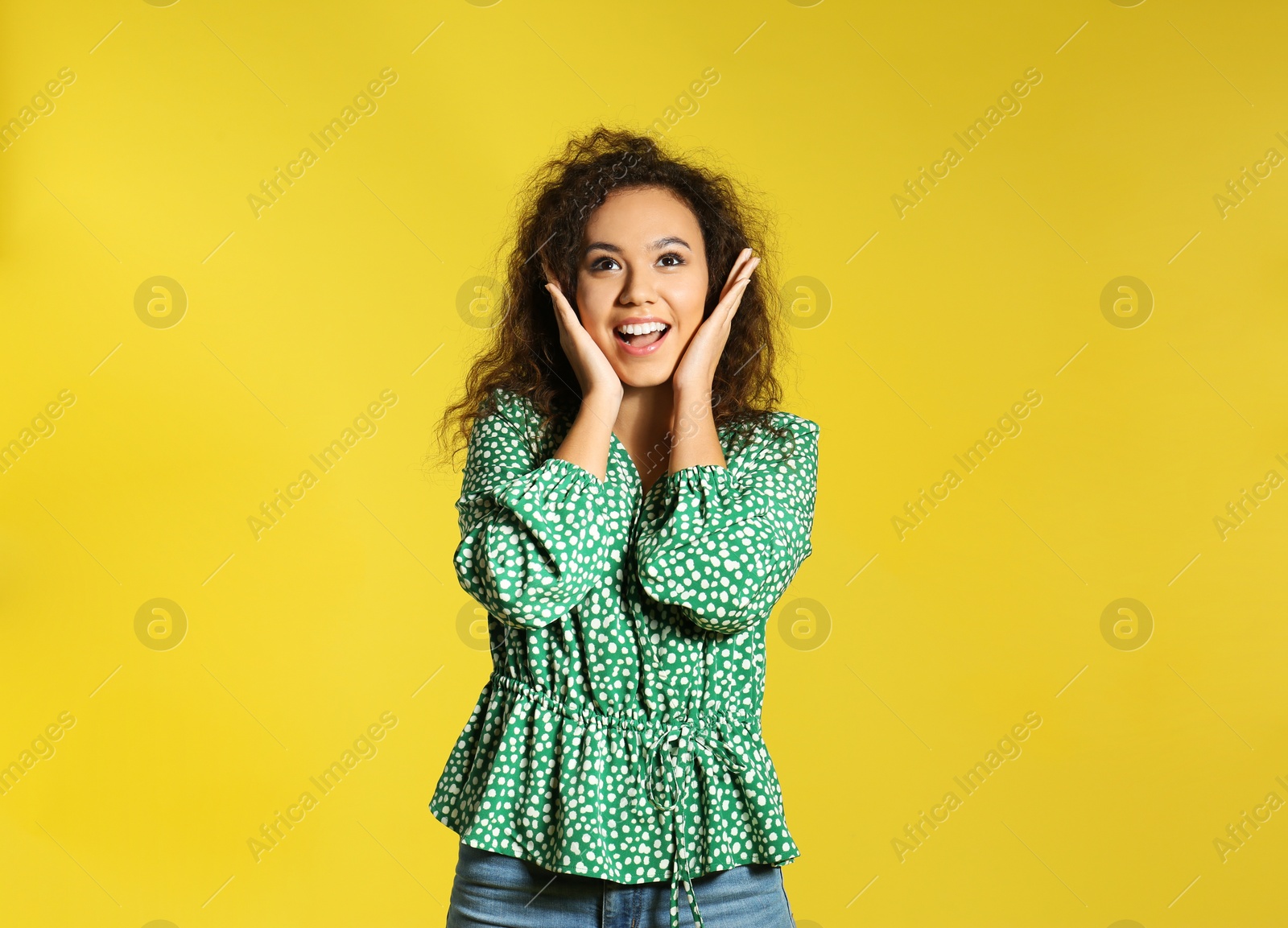 Photo of Portrait of emotional African-American woman on color background