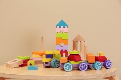 Photo of Set of different wooden toys on table against beige background