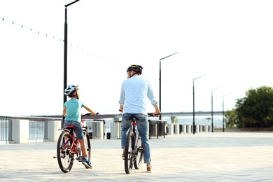 Photo of Dad and son riding bicycles together outdoors