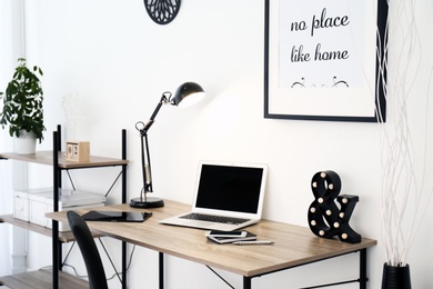 Photo of Stylish workplace with laptop on table