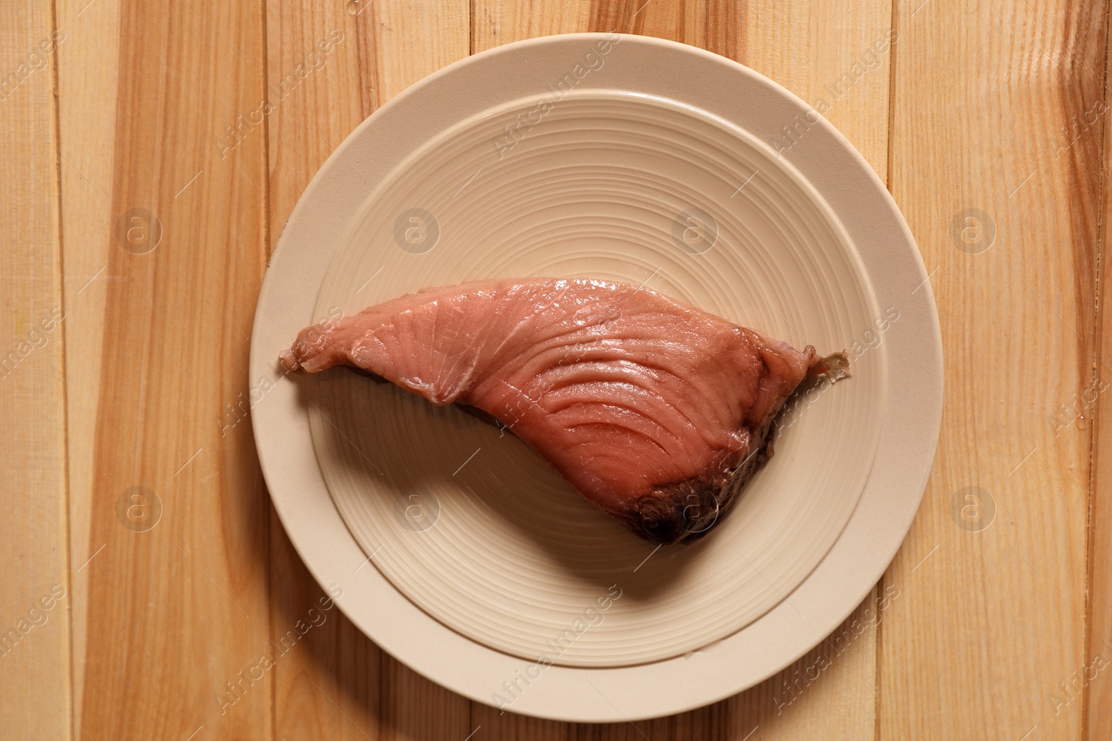 Photo of Piece of fresh raw fish on wooden table, top view