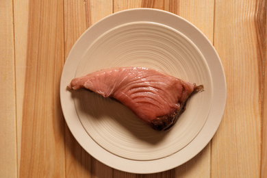 Photo of Piece of fresh raw fish on wooden table, top view