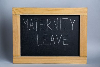 Photo of Small chalkboard with phrase Maternity Leave on grey background