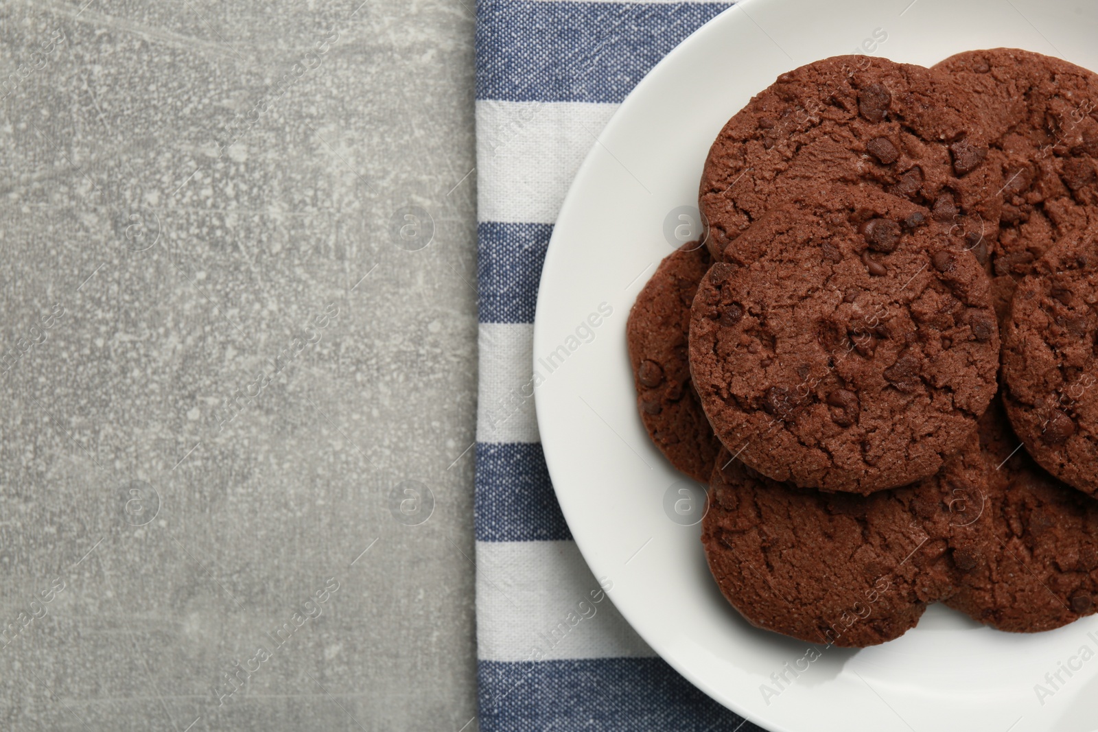 Photo of Delicious chocolate chip cookies on light grey table, top view. Space for text