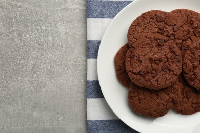 Photo of Delicious chocolate chip cookies on light grey table, top view. Space for text